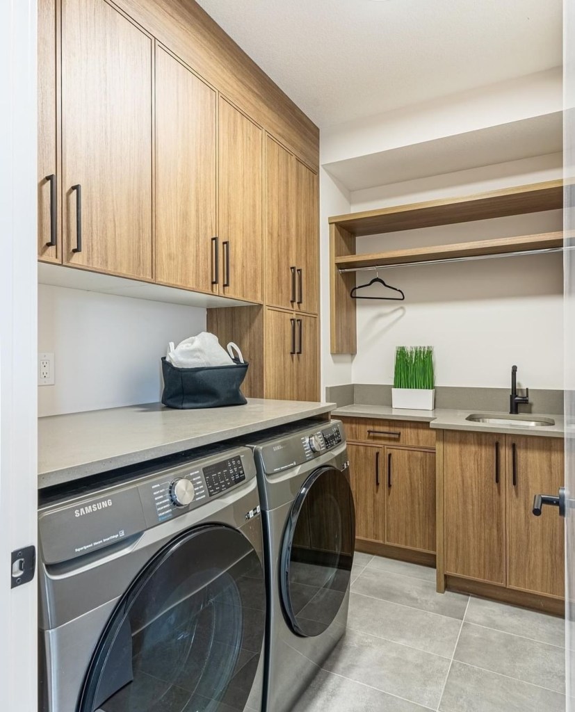 Bright organized laundry room with custom warm wood cabinets
